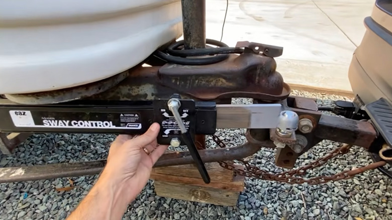 Close up of a person's hand adjusting a trailer friction bar for anti-sway functionality