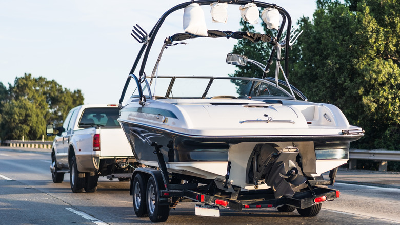 Rear 3/4 of dually pickup pulling a boat on a trailer.