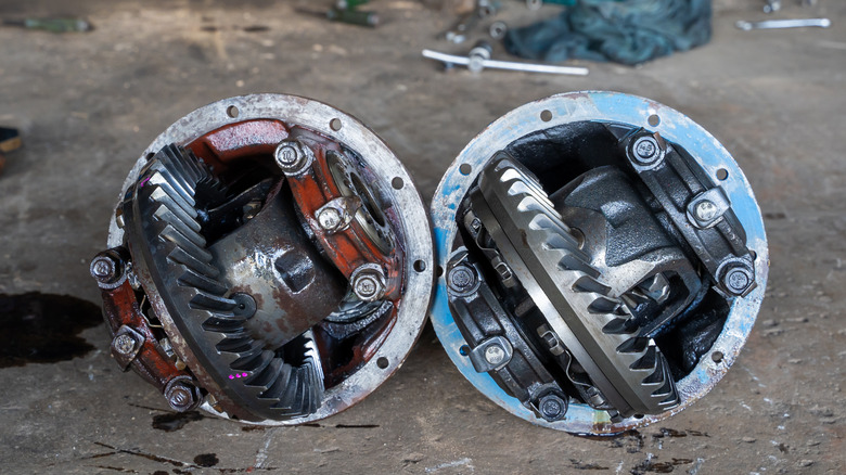 An old differential next to a new one, with both open showing their gears