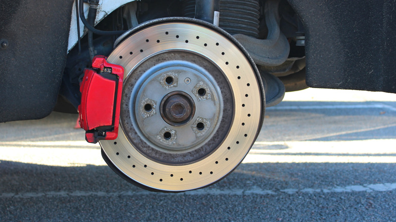 Disc brakes showing red calipers and drilled rotor for better heat dissipation