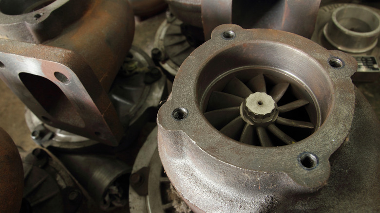 A handful of older turbochargers laid out in a workshop