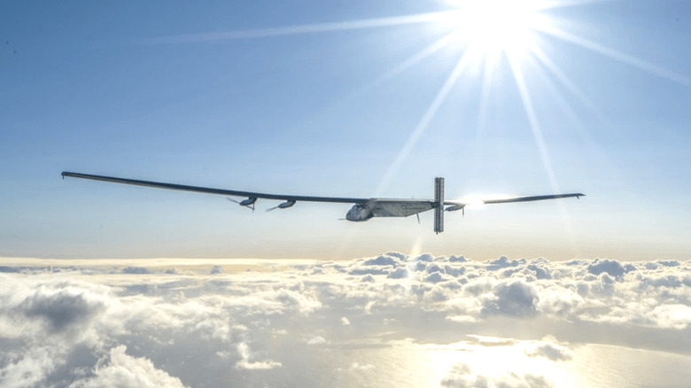Artist's rendering of a Skydweller drone flying above clouds above the sea as the sun shines down