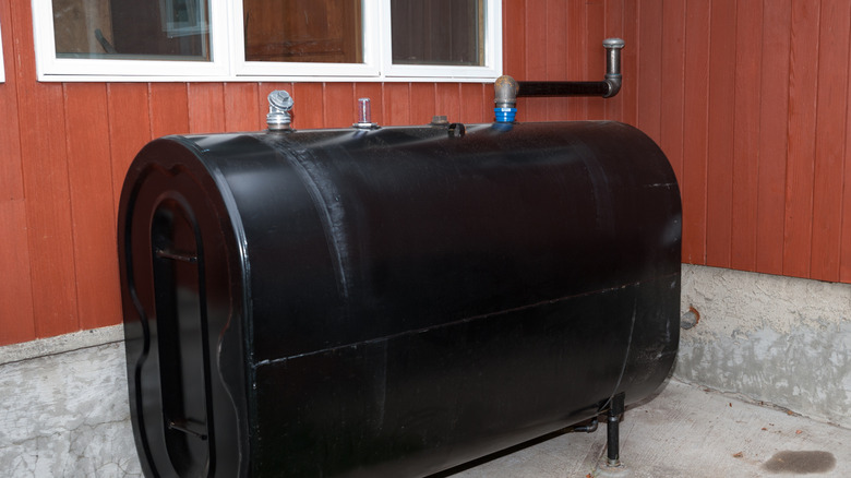 A new home heating oil storage tank in a wood-paneled basement.