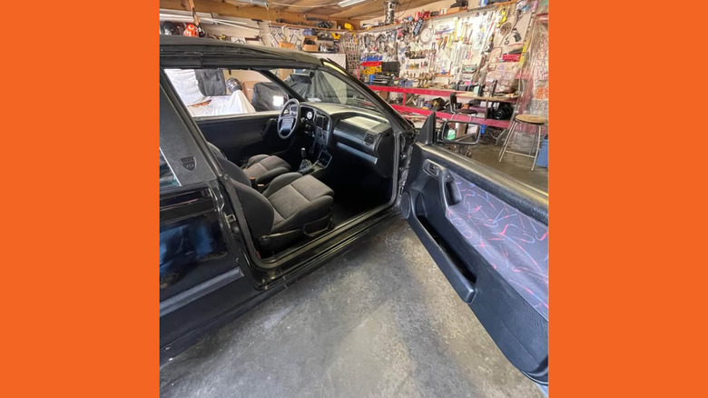 A Volkswagen Cabrio with its door open, showing multicolor fabric on the door cards and seats