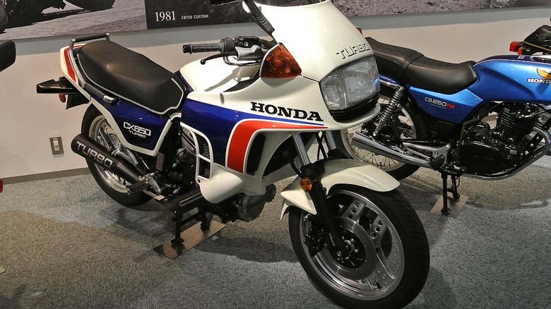 A pristine white, red, and blue Honda CX650 turbo on display at a motorbike musuem.