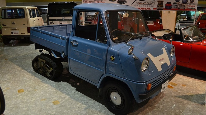 Honda T360 pickup truck with rear tracks in a museum.