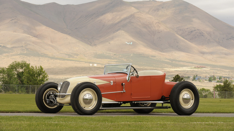 Orange and white 1925 Ford Model T track roadster seen from left with desert mountains in background