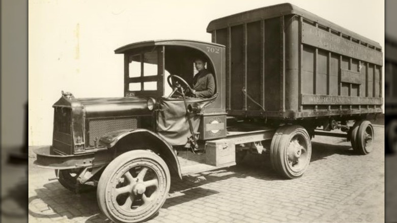 A vintage photo of a truck pulling a wagon