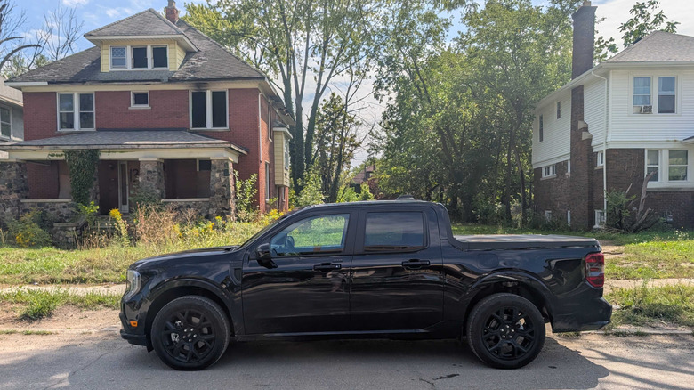 A black Ford Maverick Lobo parked in front of an abandoned house
