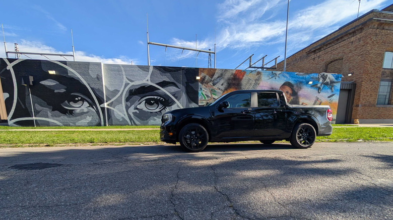 A black Ford Maverick Lobo parked in front of some street art on a sunny day