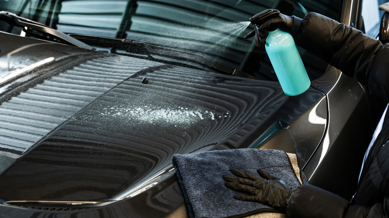A person cleaning a car with a spray bottle
