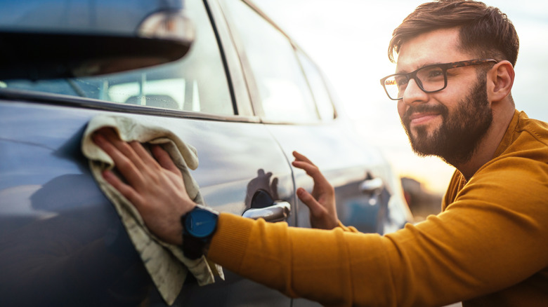 A person wiping a car's door