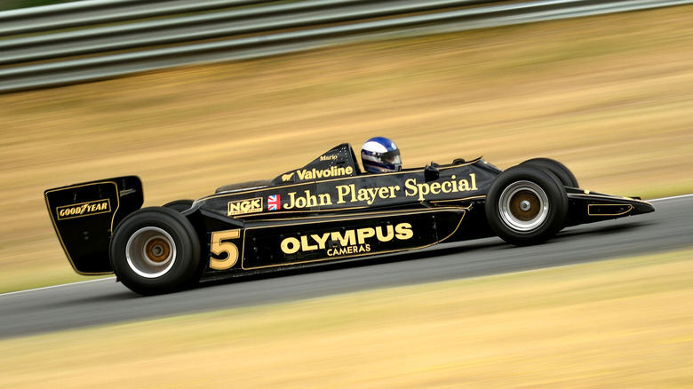 A side profile photo of a Lotus 79 race car on a track