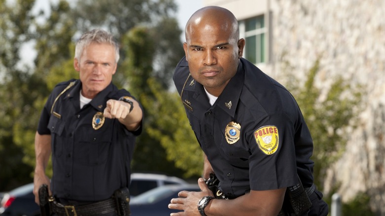 One officer about to draw his gun while another officer points