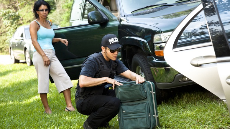 Officer searches a woman luggage at a traffic stop