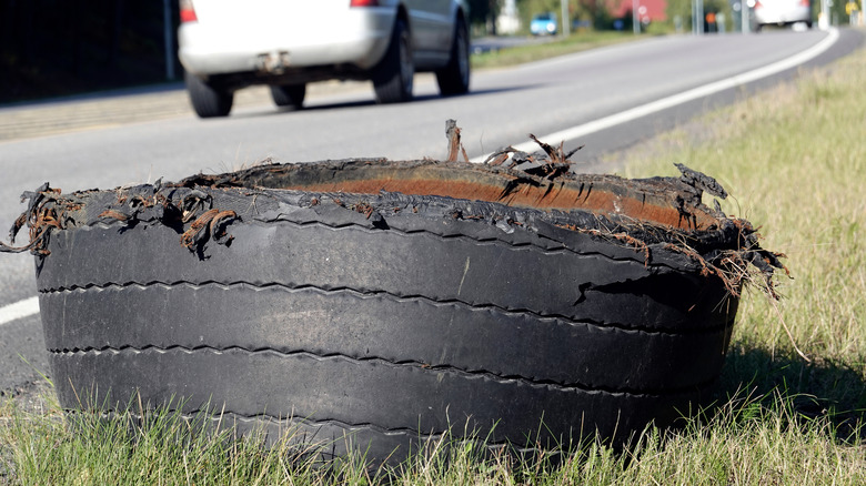An exploded semi truck tire on the side of the road