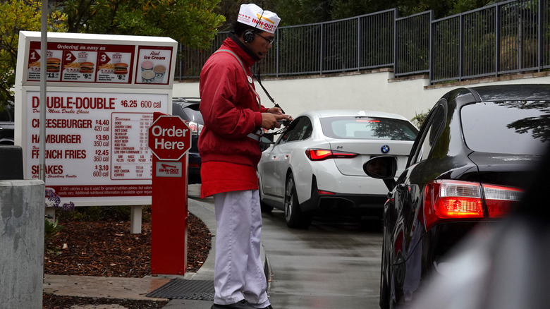 DALY CITY, CALIFORNIA - JULY 21: A worker takes orders in the drive-thru lane at an In-N-Out Burger restaurant on July 21, 2025 in Daly City, California. In-N-Out Burger heiress and CEO Lynsi Snyder announced that she will be relocating her family from California to Tennessee, citing the challenges of raising a family and running a business in the state. In-N-Out has more than 280 restaurants in eight states. (Photo by Justin Sullivan/Getty Images)