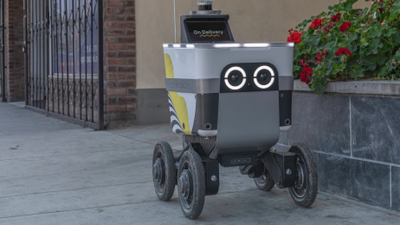 A food delivery drone rolls down the street.