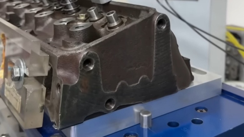 A Chevrolet double hump cylinder head mounted to a flow bench for testing.