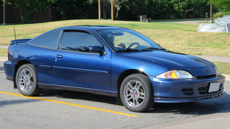 A blue Chevrolet Cavalier coupe in a parking spot.