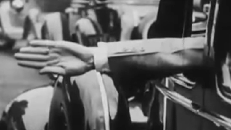 A driver sticking their hand out of a window.