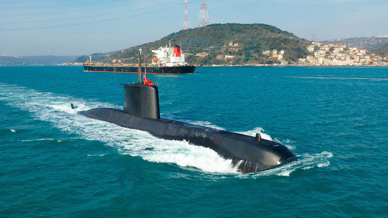 Navy submarine underway full speed on the calm waters of the Bosphorus, waving the Turkish flag