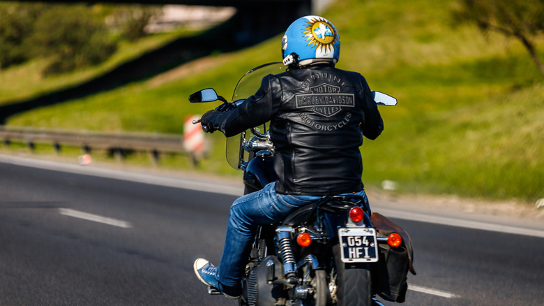 A man riding a Harley-Davidson wearing a leather jacket