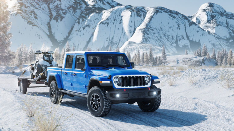 Blue Jeep Gladiator driving and towing through snow.