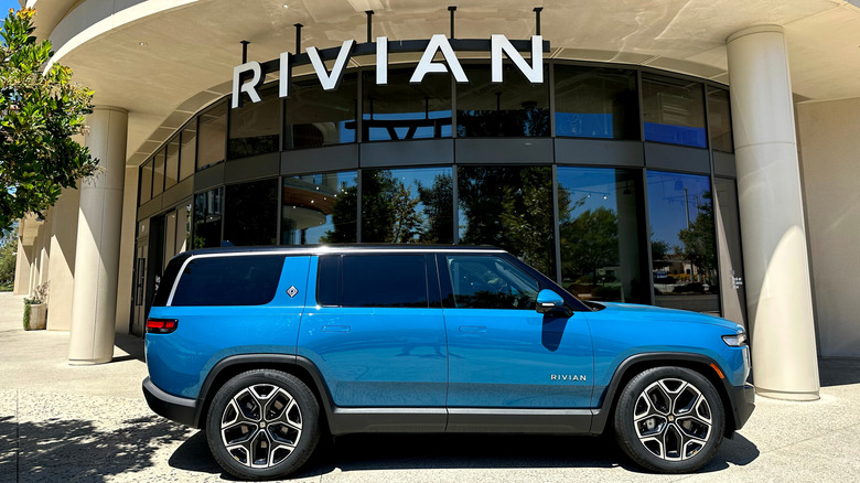 A blue Rivian SUV parked outside the company's showroom