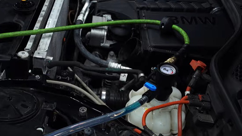 Vacuum cleaning the coolant system of a BMW N55 engine before replacing the water pump