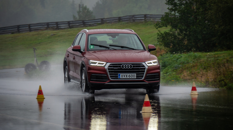 An Audi SUV braking under wet surface conditions.