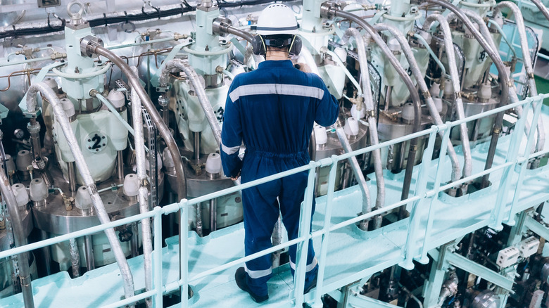 Worker inspects a ship's engine.