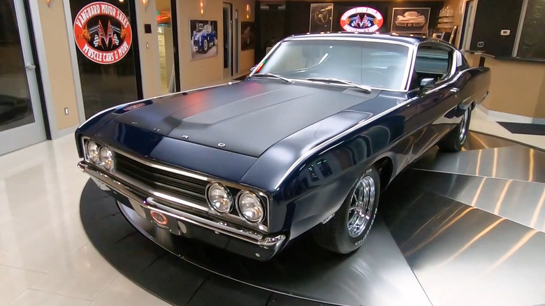 A black 1969 Ford Torino Talladega Coupe in a showroom