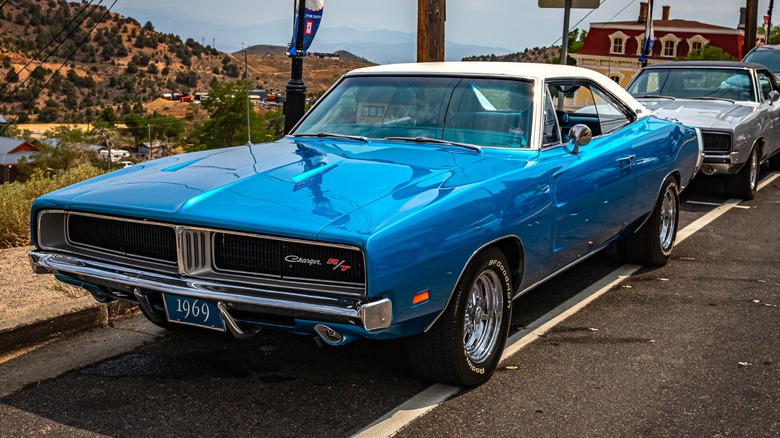 A blue 1969 Dodge Charger driving fast on the road