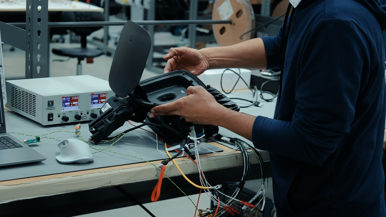 An engineer holding a charge port