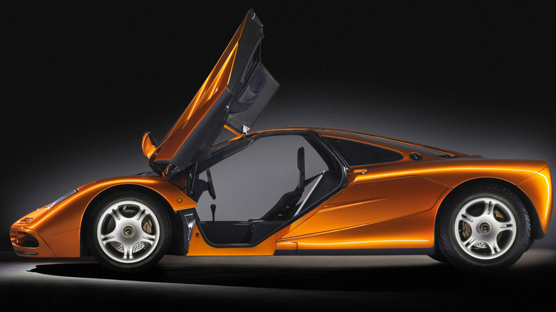 A McLaren F1 from the side with its doors open.