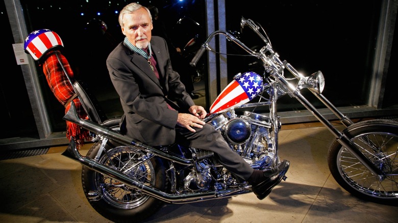 Dennis Hopper sitting on the Captain America Harley-Davidson Chopper from the film "Easy Rider."