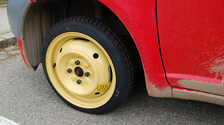 A vehicle with a temporary doughnut spare tire installed.