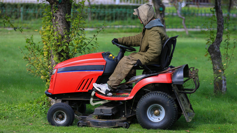 A oerson operating a lawn mower tractor