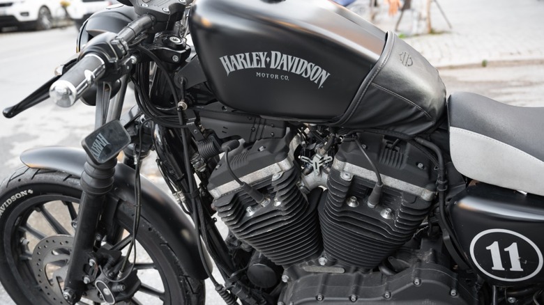 Black Harley-Davidson Sportster Iron 883 parked on a street.