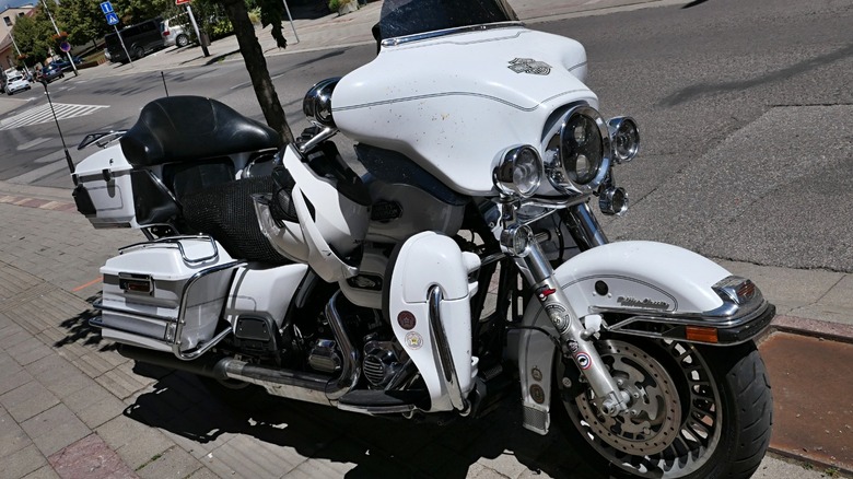 White Harley Davidson Electra Glide parked on a street.