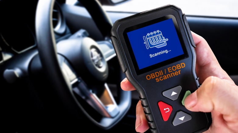 A handheld OBD-II code scanner, running a vehicle diagnostic.