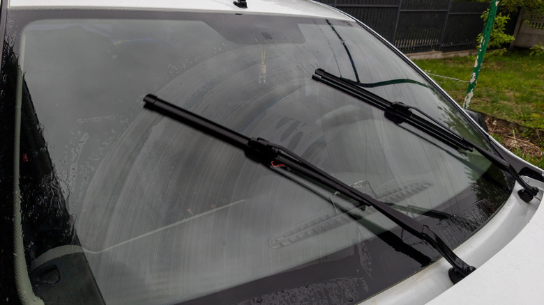 Wiper blades on a windshield with streak marks.