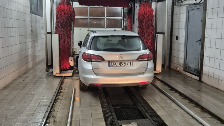A vehicle being cleaned in an automatic car wash.