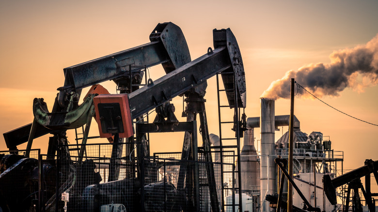 Active oil wells against a sunset.