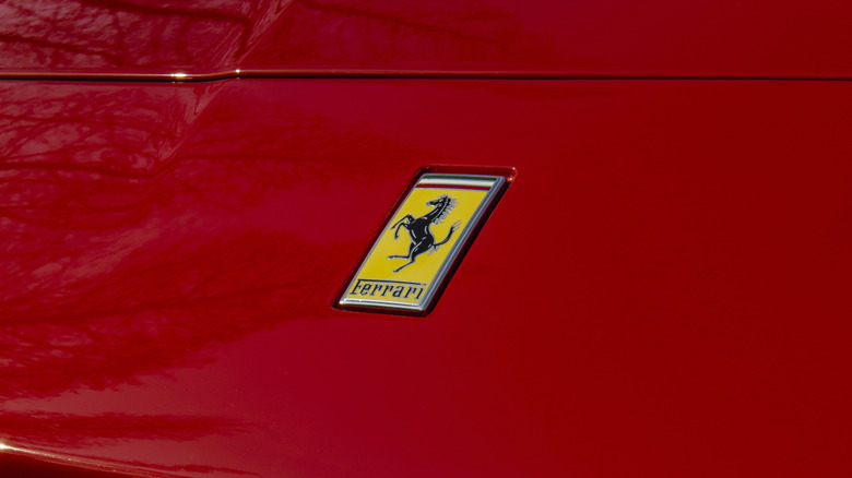 A close-up of the Ferrari logo on the hood of a red car.