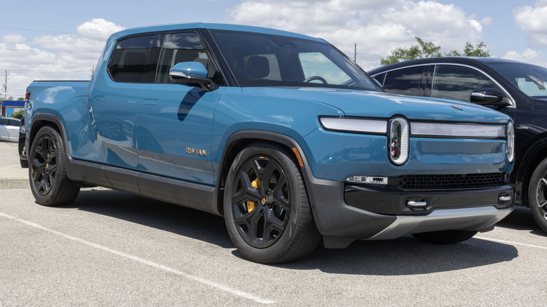 A teal Rivian R1T truck in a parking lot.