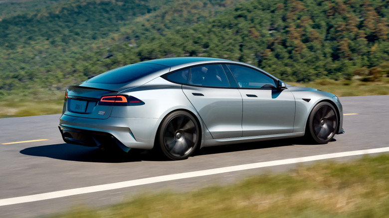 3/4 rear action shot of a silver Tesla Model S