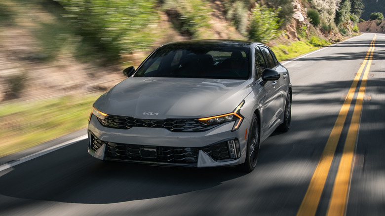 Frontal view of a gray 2025 Kia K5 on the highway