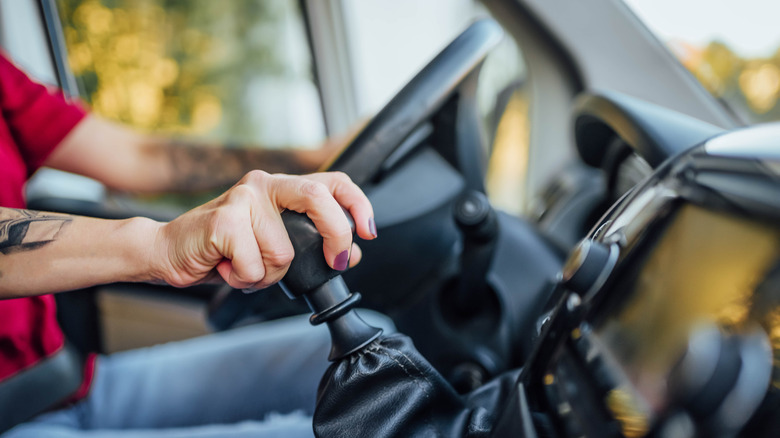 Close-up of a woman shifting gears in a car